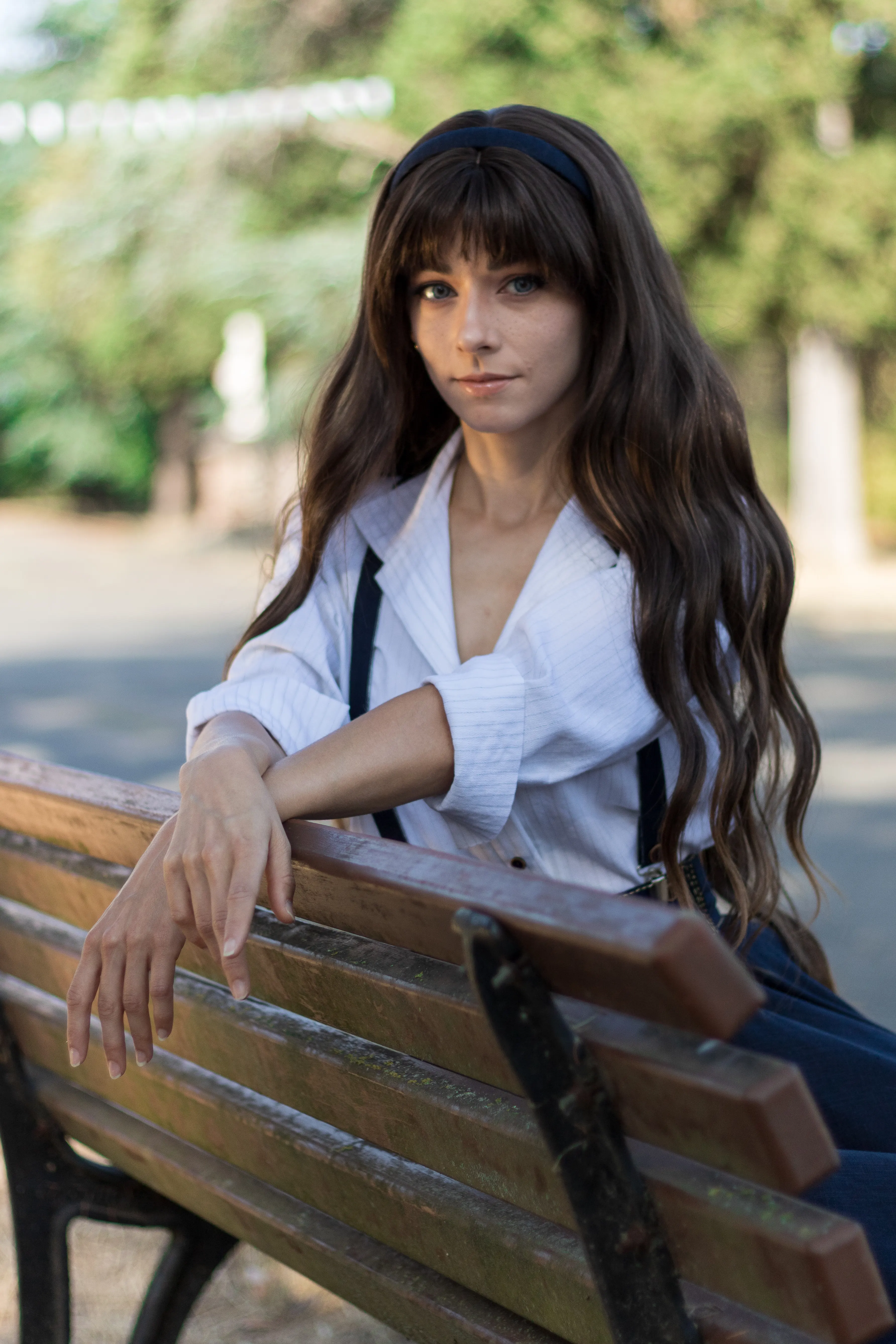Clea Dessendre from Clair Obscur: Expedition 33, sitting on a park bench, arm resting on the backrest, Ryuu Seika cosplay