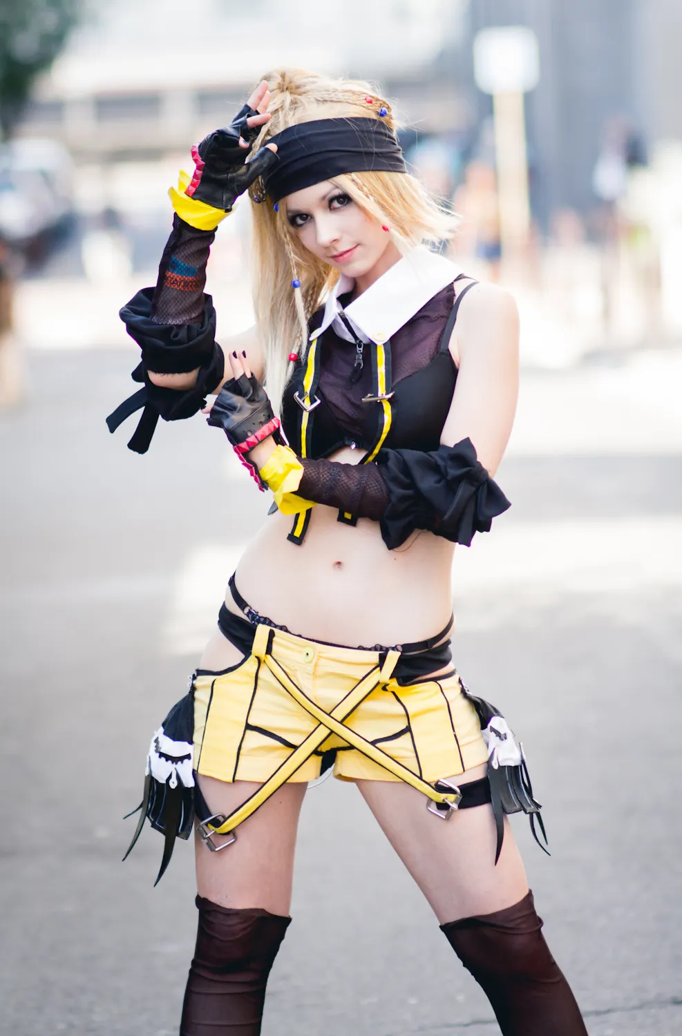 Rikku ninja version from Final Fantasy X-2 in a full-body pose in the street, black and yellow costume with straps and headband, based on an original design by vinrylgrave, cosplay by Ryuu Seika 2012