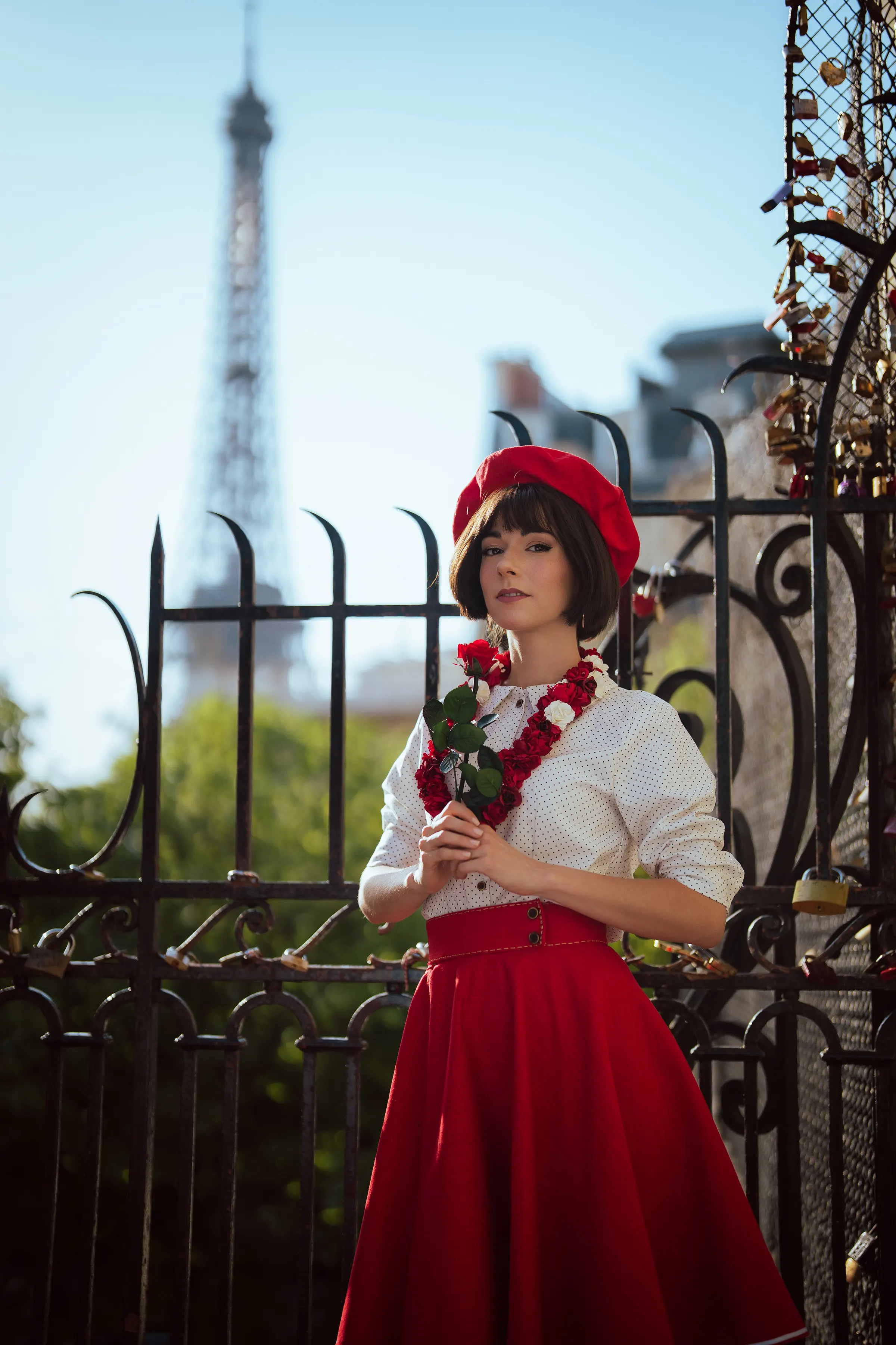 Sophie de Clair Obscur: Expédition 33, une rose à la main devant un grillage de cadenas et la Tour Eiffel, cosplay Ryuu Seika